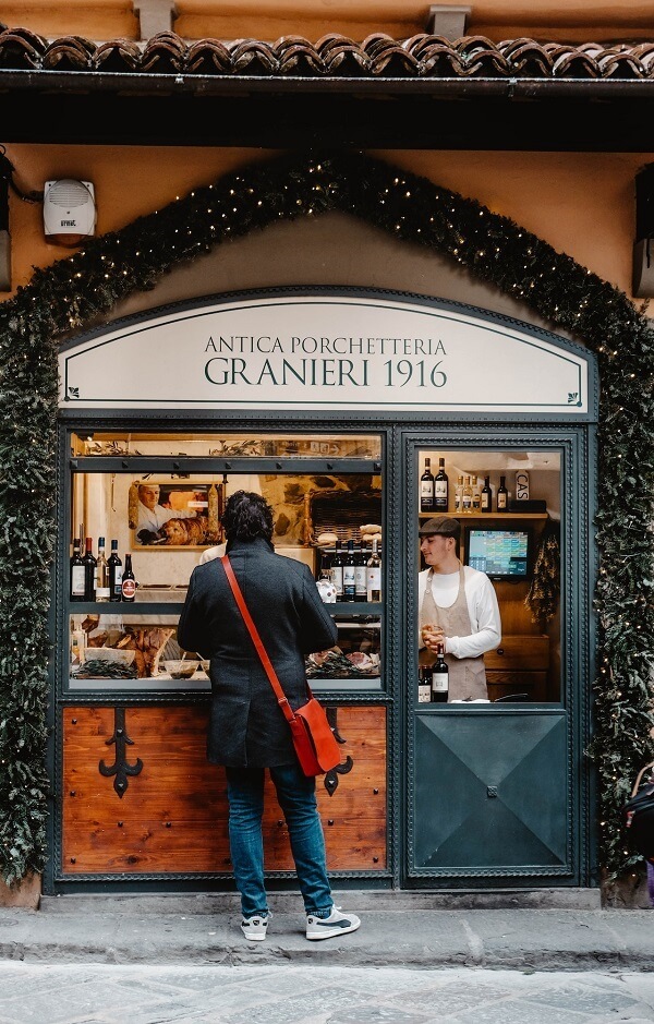 A customer is buying a typical Florentine sandwich with porchetta
