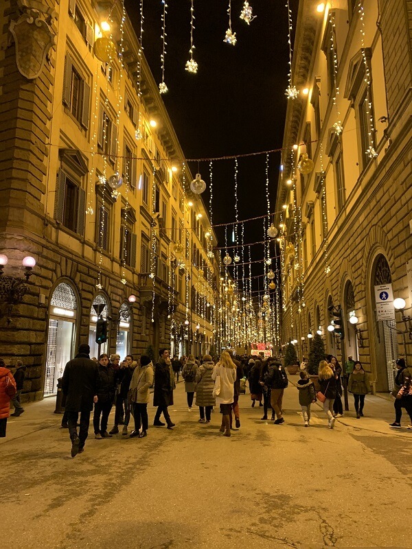 Tourists walk the snowy streets of Florence in winter.