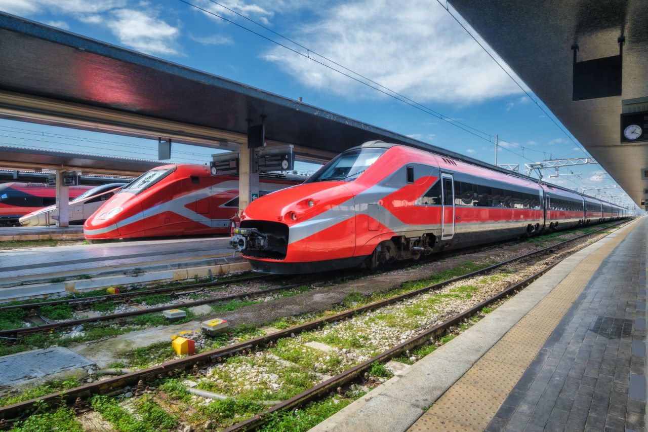 This is a picture of a speeding train in front of an Italian station