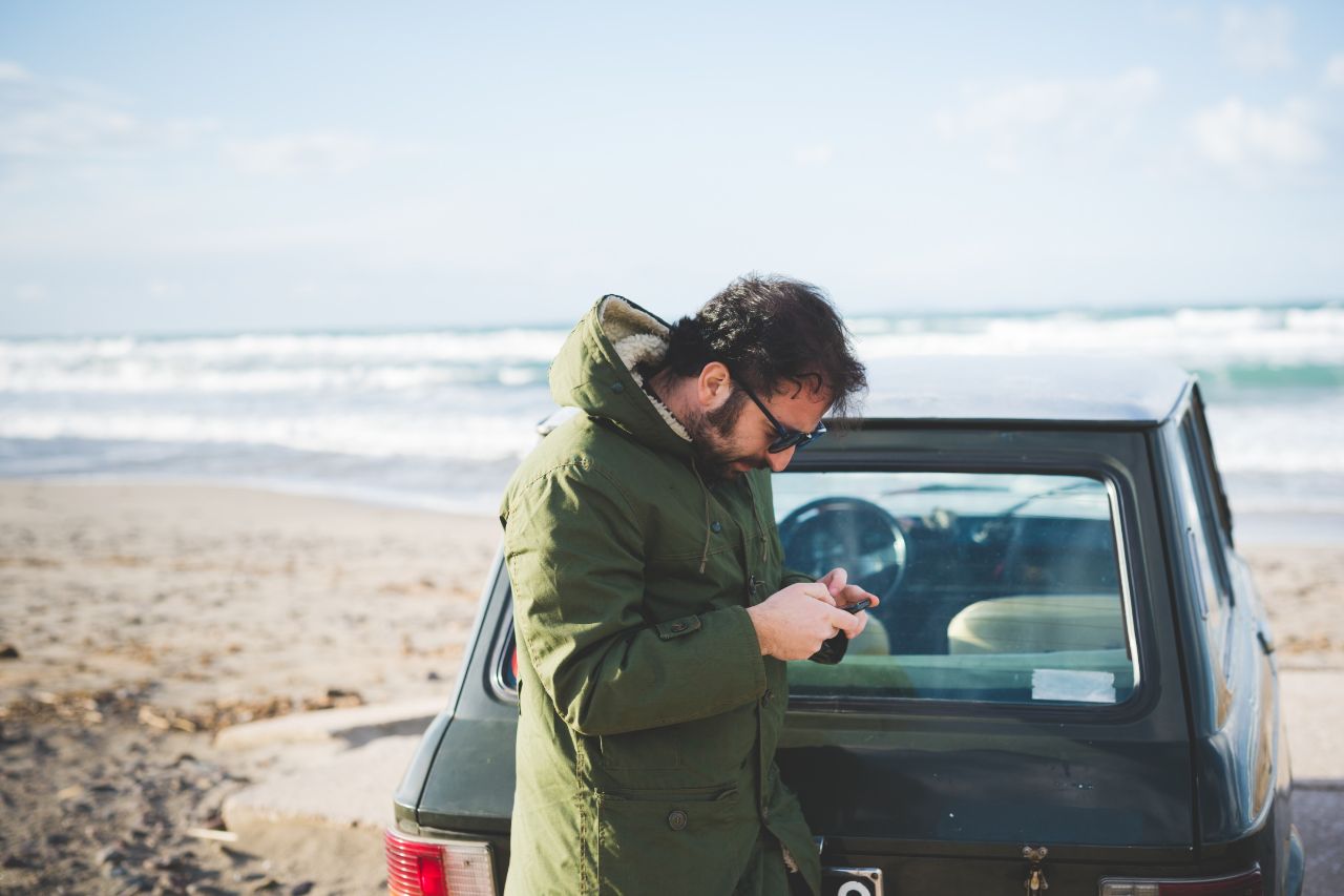 In this picture, a man who rented a car is checking some of the driving laws in Italy