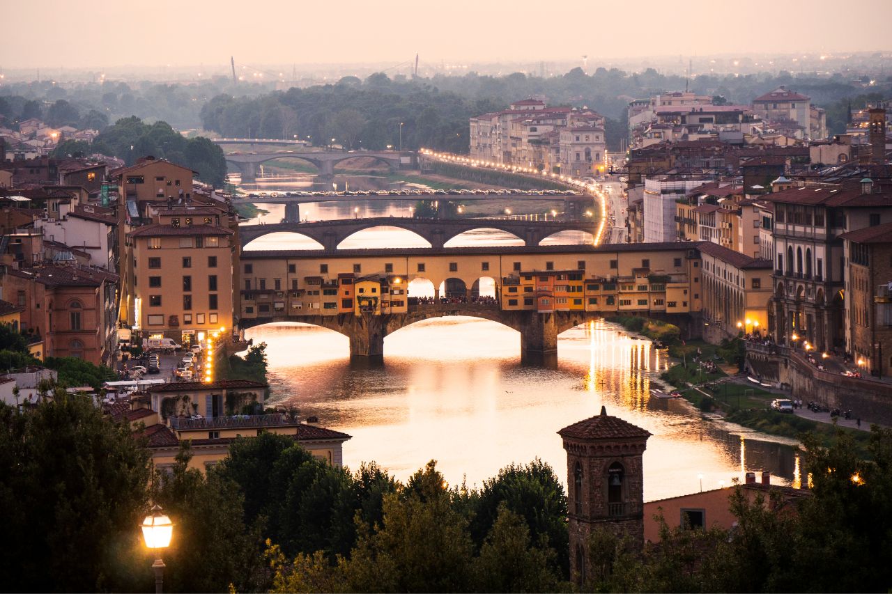 The Ponte Vecchio photographed in a typical November sunset, while the sunlight is reflected on the Arno river.
