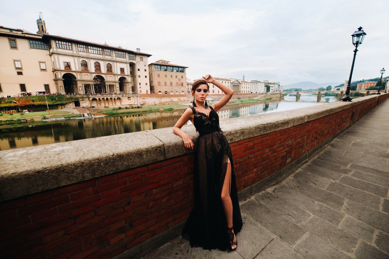 A girl model is doing a photo shoot with high fashion black clothes in Florence