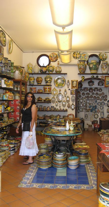 A tourist is shopping in a typical local shop in Via dei Rufolo, in Ravello
