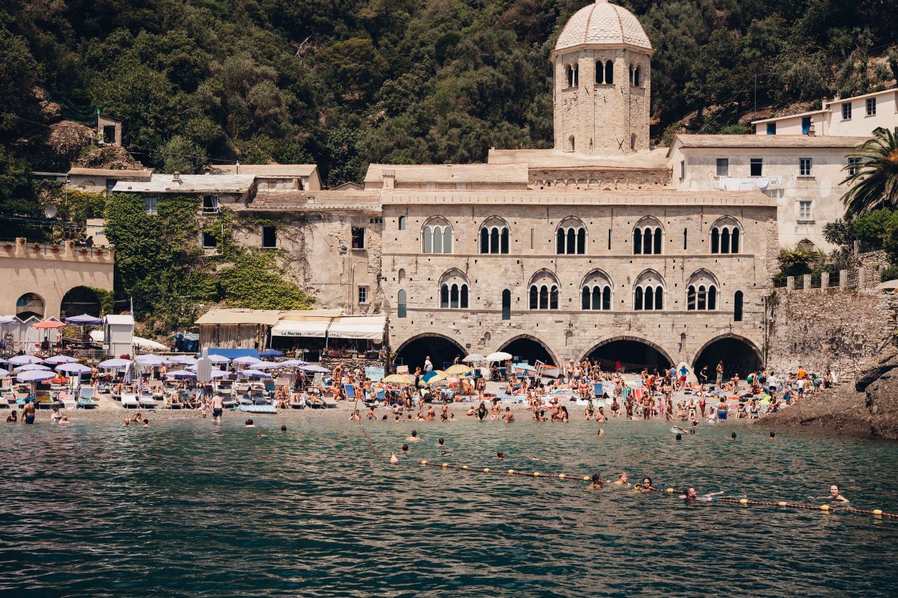 Many tourists enjoy a sunny day at the beach on the Amalfi coast.