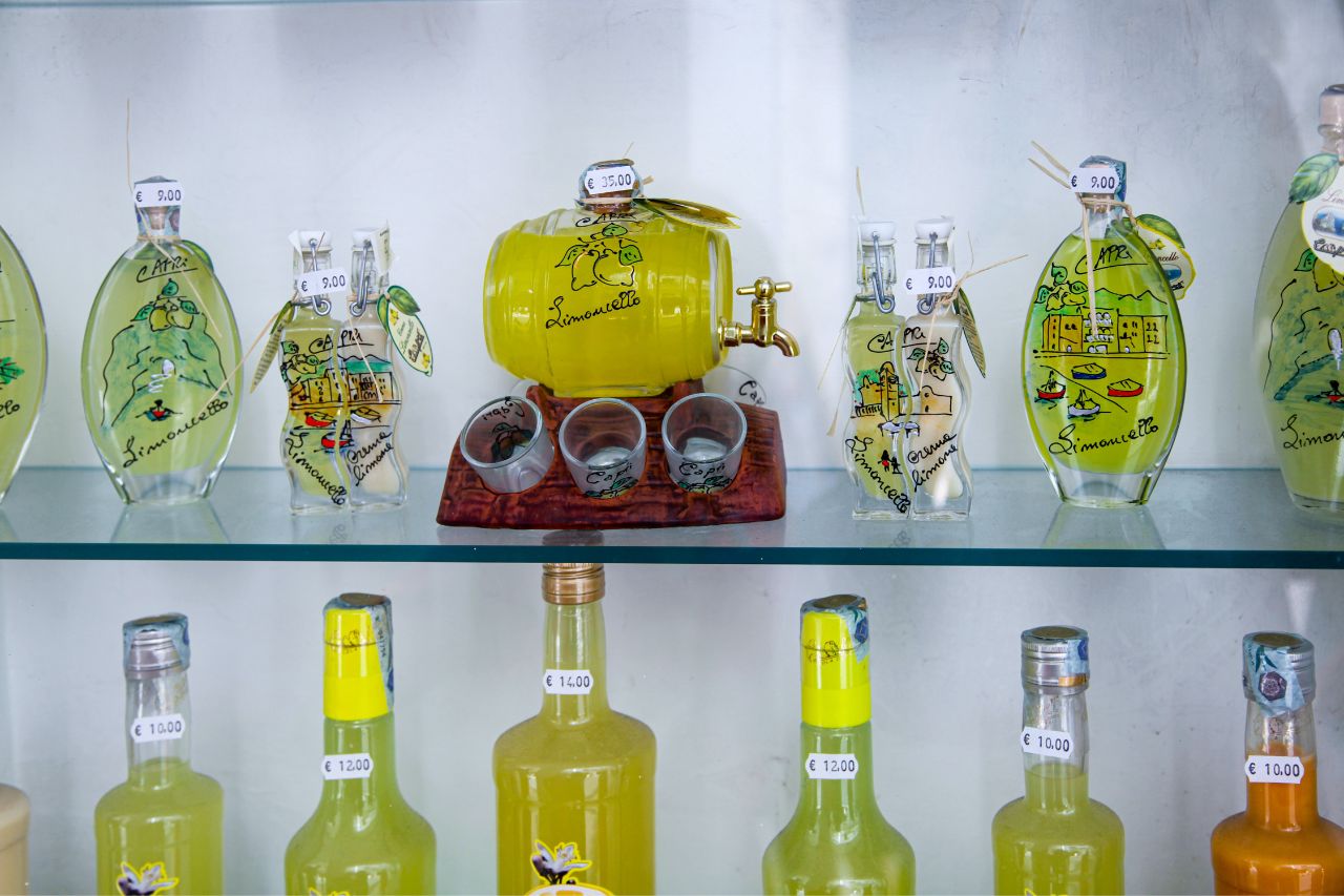 Different beautiful bottles of limoncello with prices indicated.