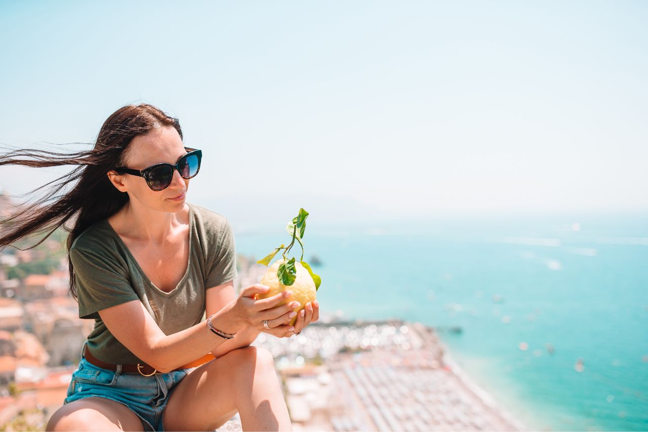 A picture of tourist holding a big lemon on the Amalfi Coast