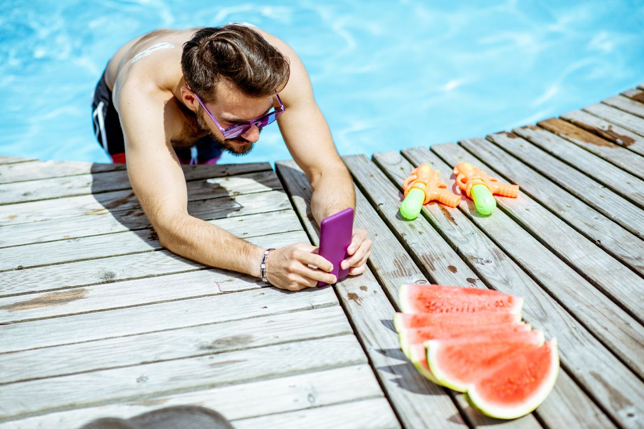 A man capturing a watermelon at the pool.
