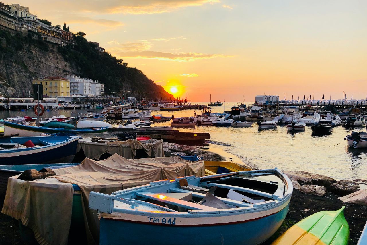 Many boats parked on Amalfi coast with beautiful sunset.