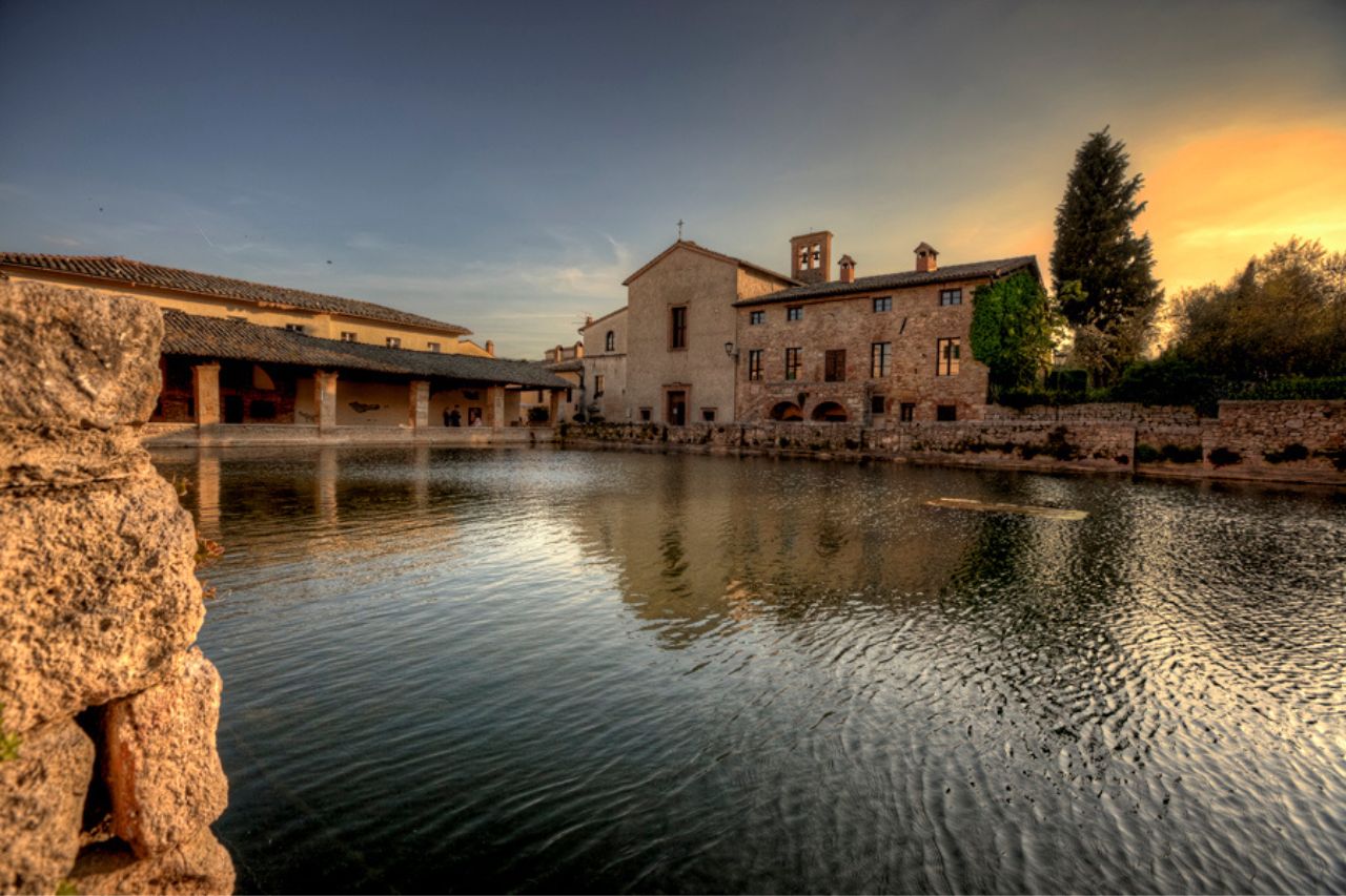 A calm water river surrounded by Roman architectural buildings