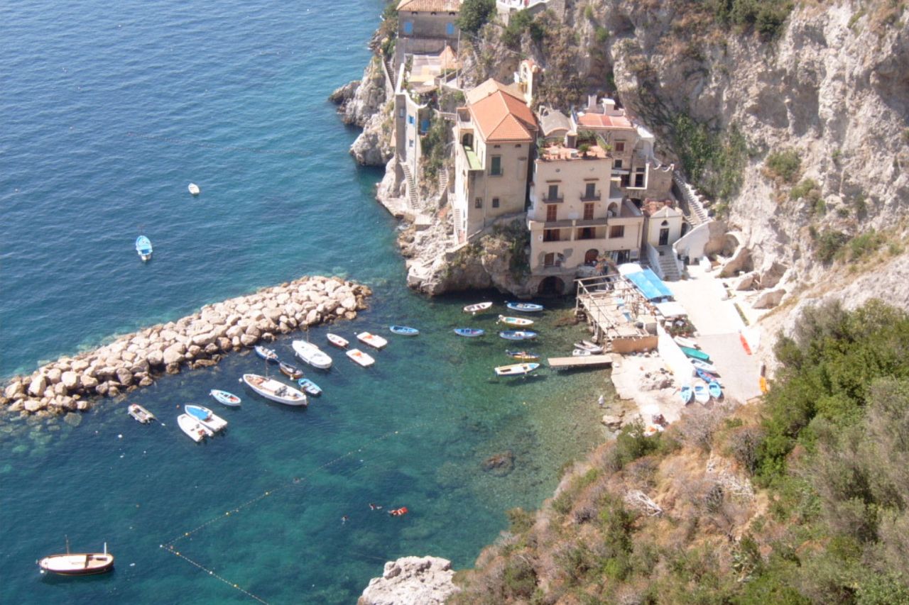 Above view of the Marina di Conca beach with boats over the crystal clear water.