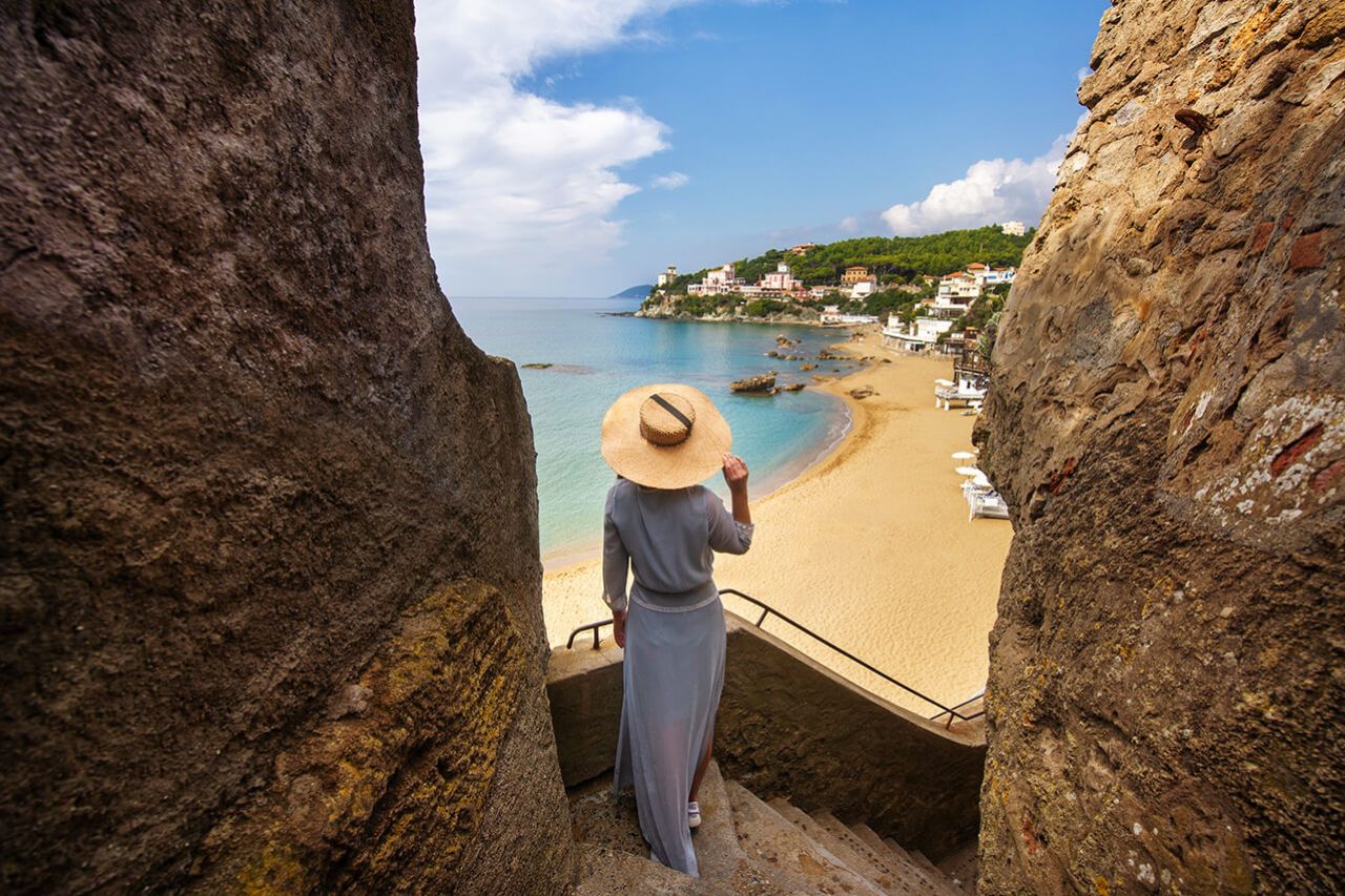 A woman enjoys the view of the beach from the stairs leading to the Alberto Sordi seafront
