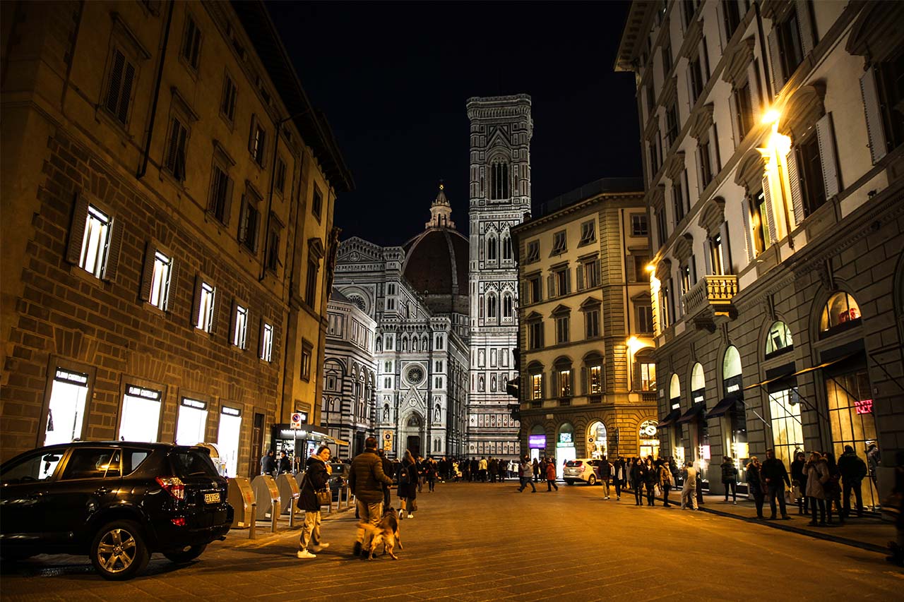 In Florence, the tourists are going to church, shopping and enjoying hot drinks with a winter night.