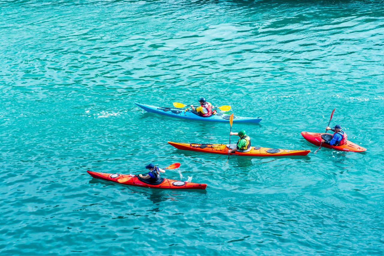 A group of tourists enjoy kayaking In Maiori  with crystal clear water.