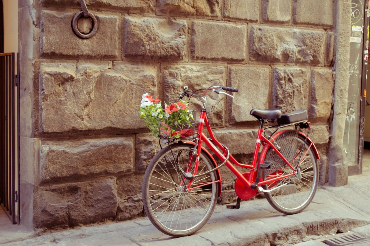 A beautiful red bike parked in front of shop in Lucca.
