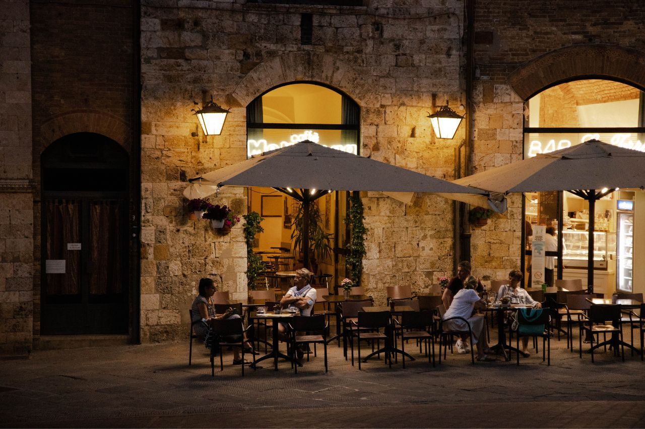 Tourists are having an aperitif in San Gimignano, a medieval village in Tuscany
