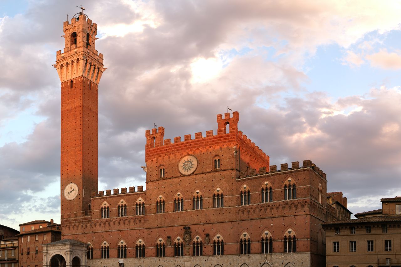 The famous Palazzo Pubblico with sunset is located in Siena, an ideal place to visit with a car itinerary from Florence