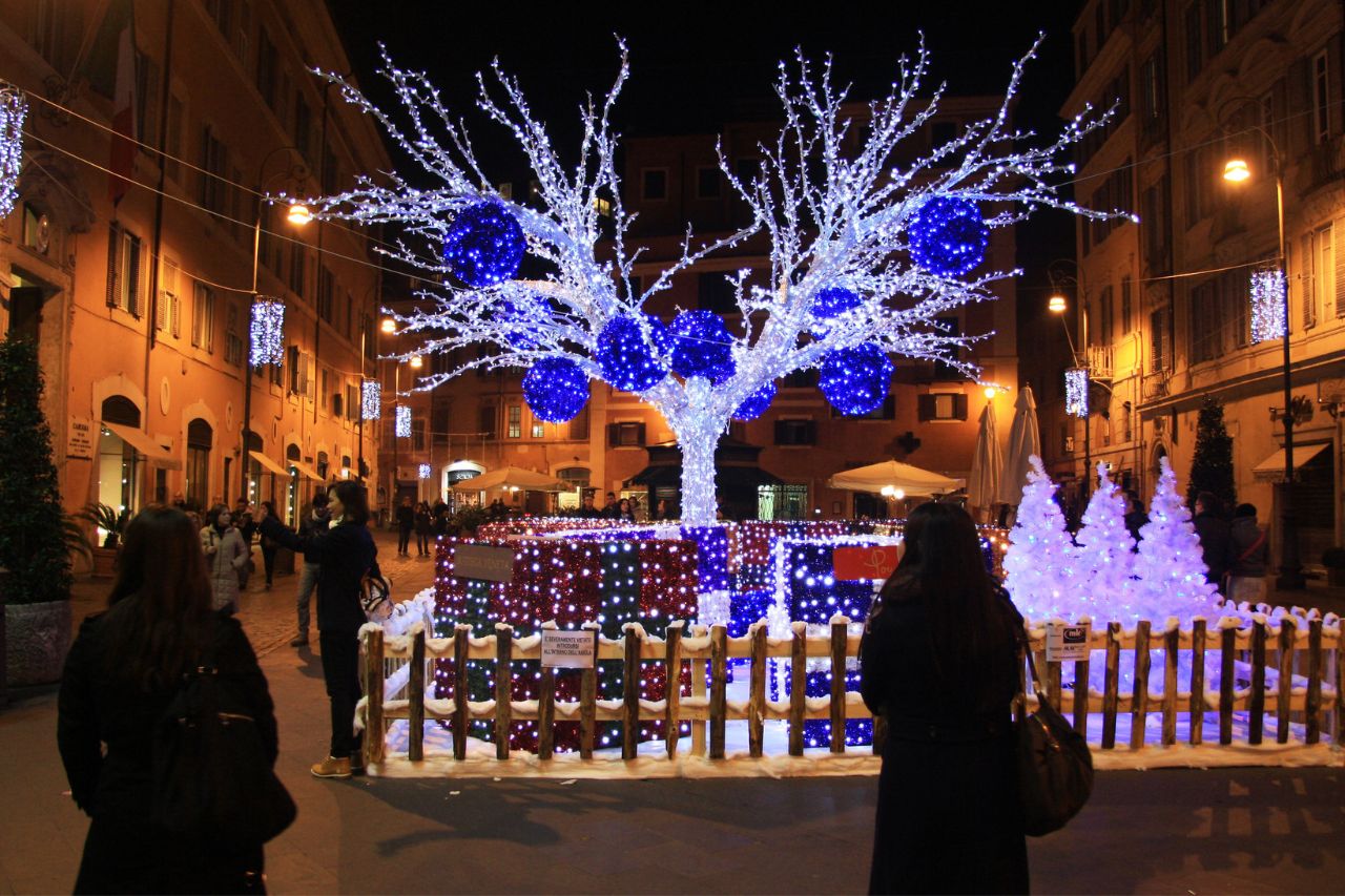 Tourists enjoy walking in the town of Rome with Christmas lights in the streets.
