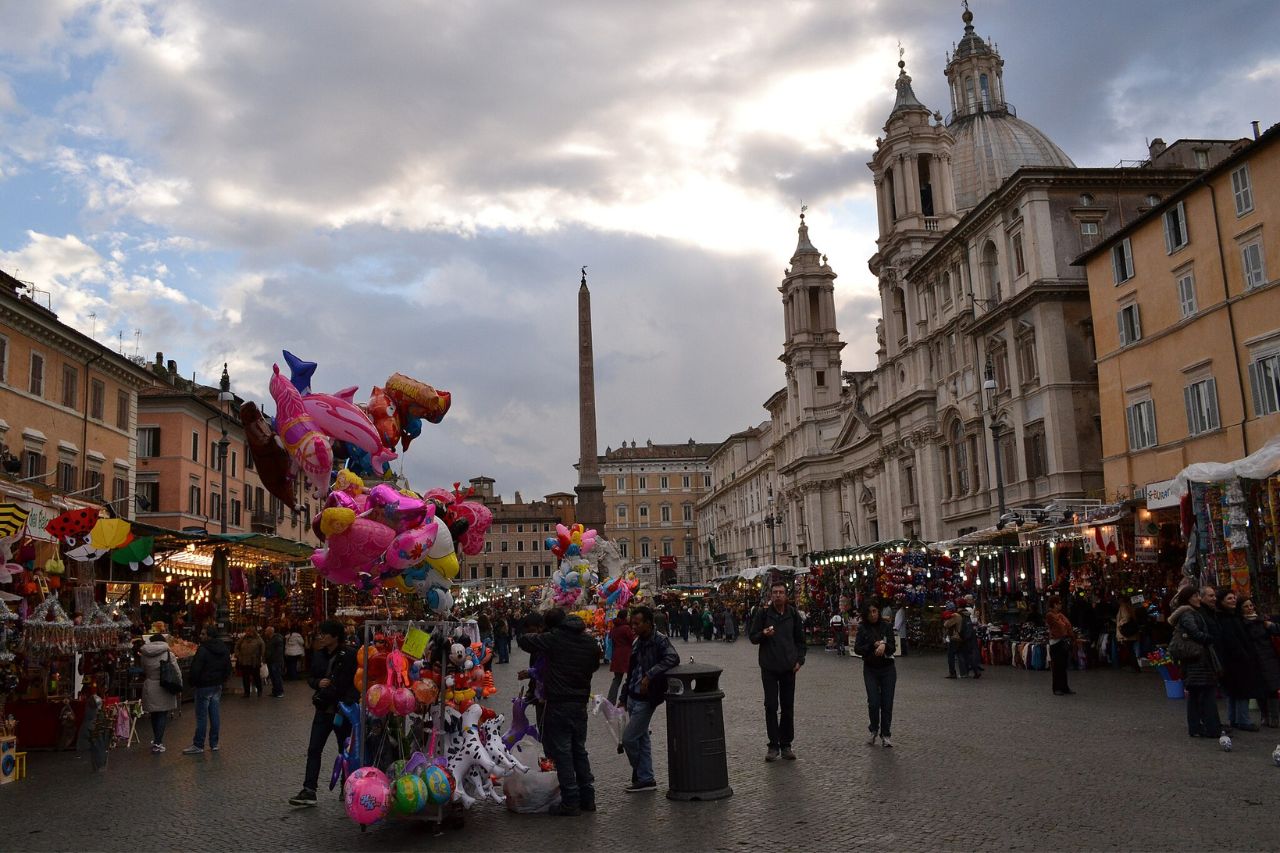 Tourists enjoy shopping with proper winter clothes at the Christmas market in Rome, Italy.