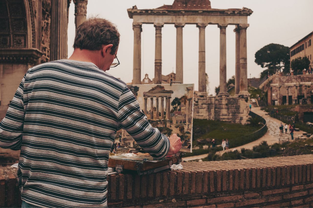 A street artist is painting a Roman monument and then selling it to tourists