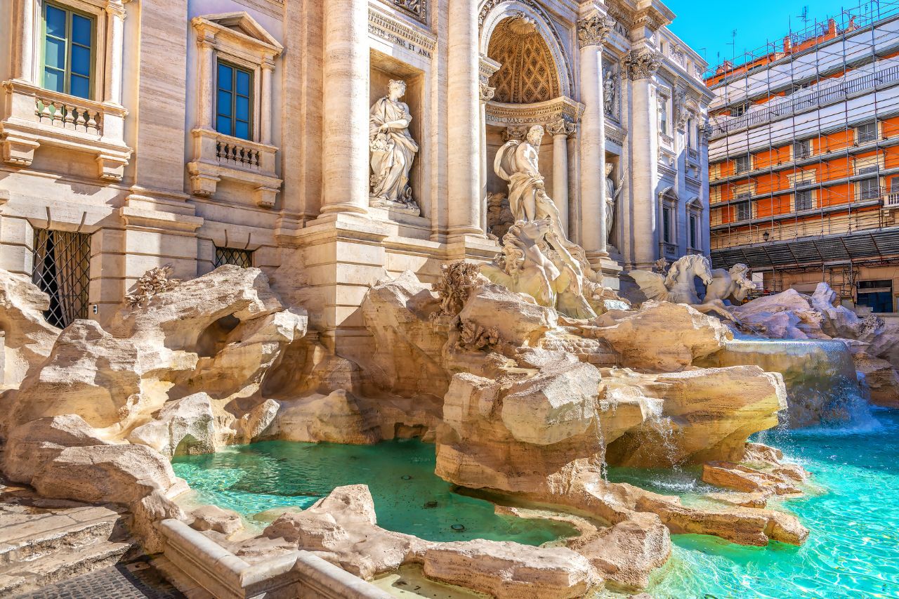 The beautifulTrevi Fountain with white sculptures is located in Rome, Italy.