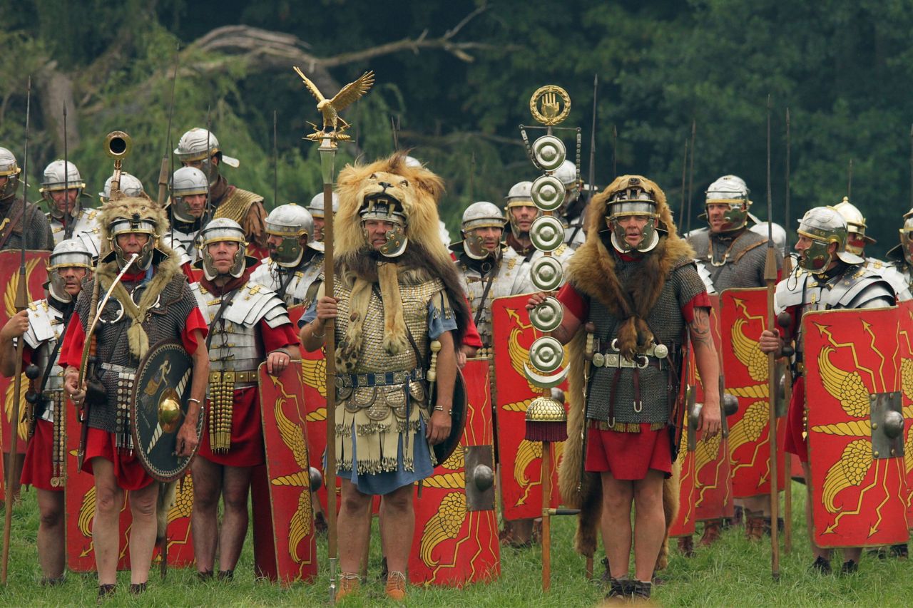 Some soldiers are replicating the Roman army formation with the armor and swords of the time