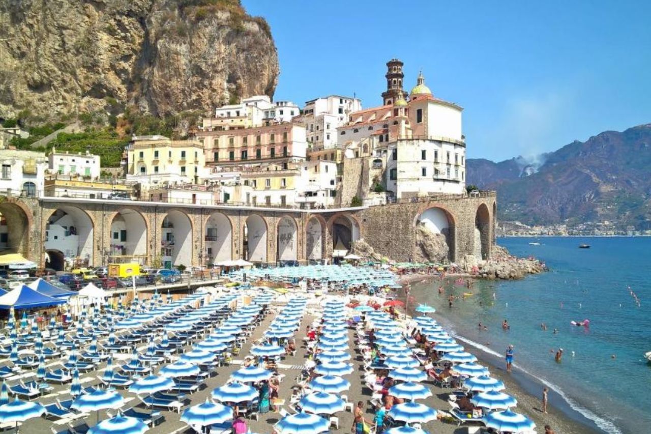 Tourists enjoy bathing at the beach of Atrani near the excellent hotels of the Vicolo 23 House