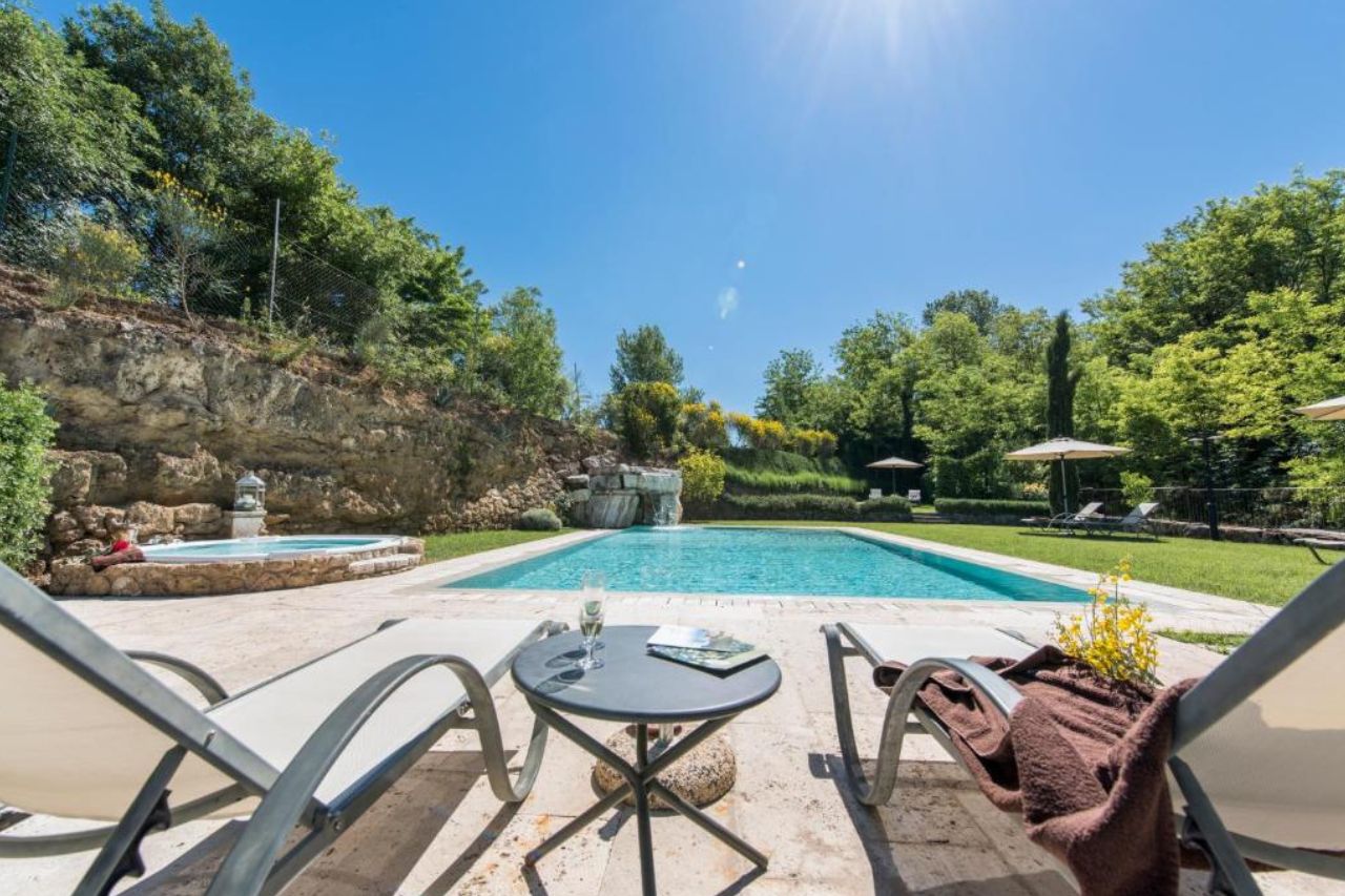 Beautiful swimming pool surrounded by trees and gardens at Molino Della Lodola