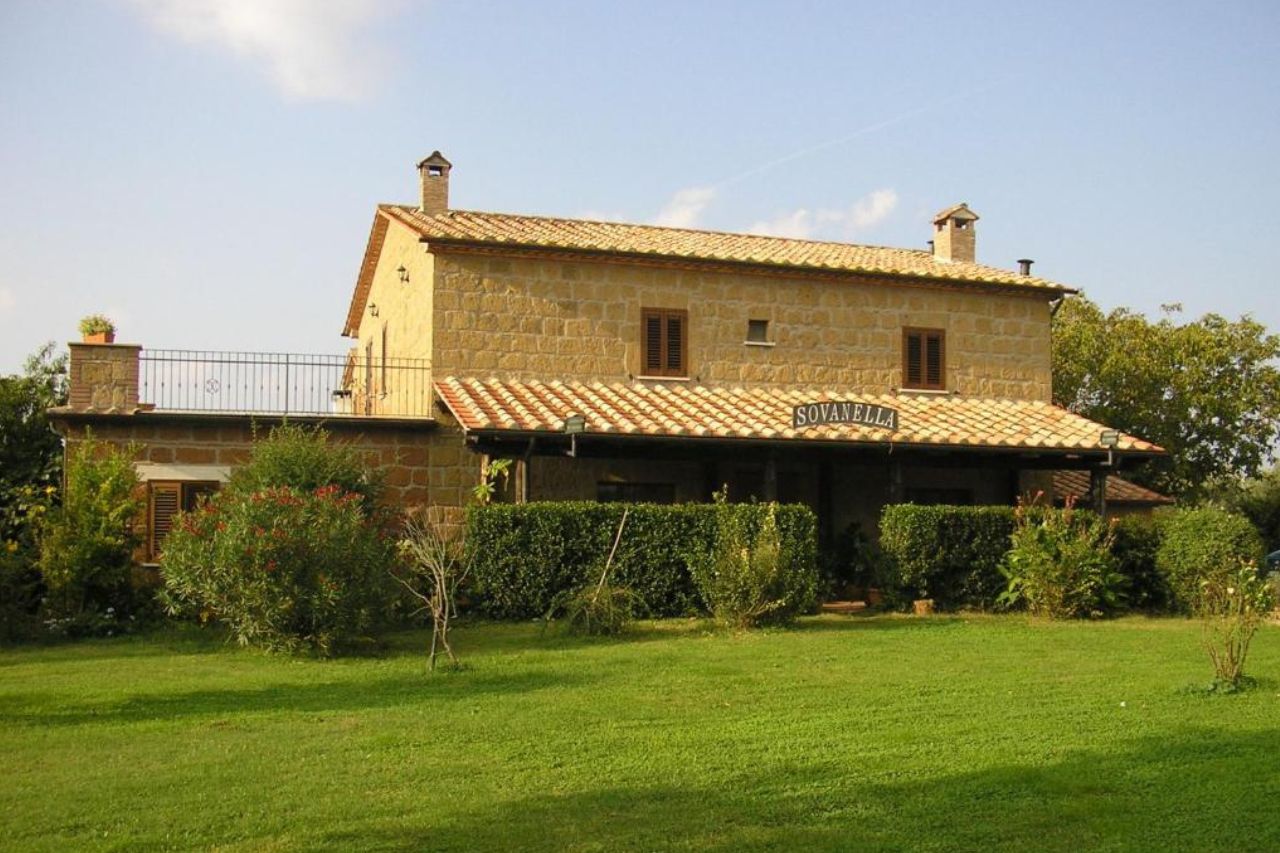 The medieval hotel of the Agriturismo Sovanella with beautiful sunlight and greens.