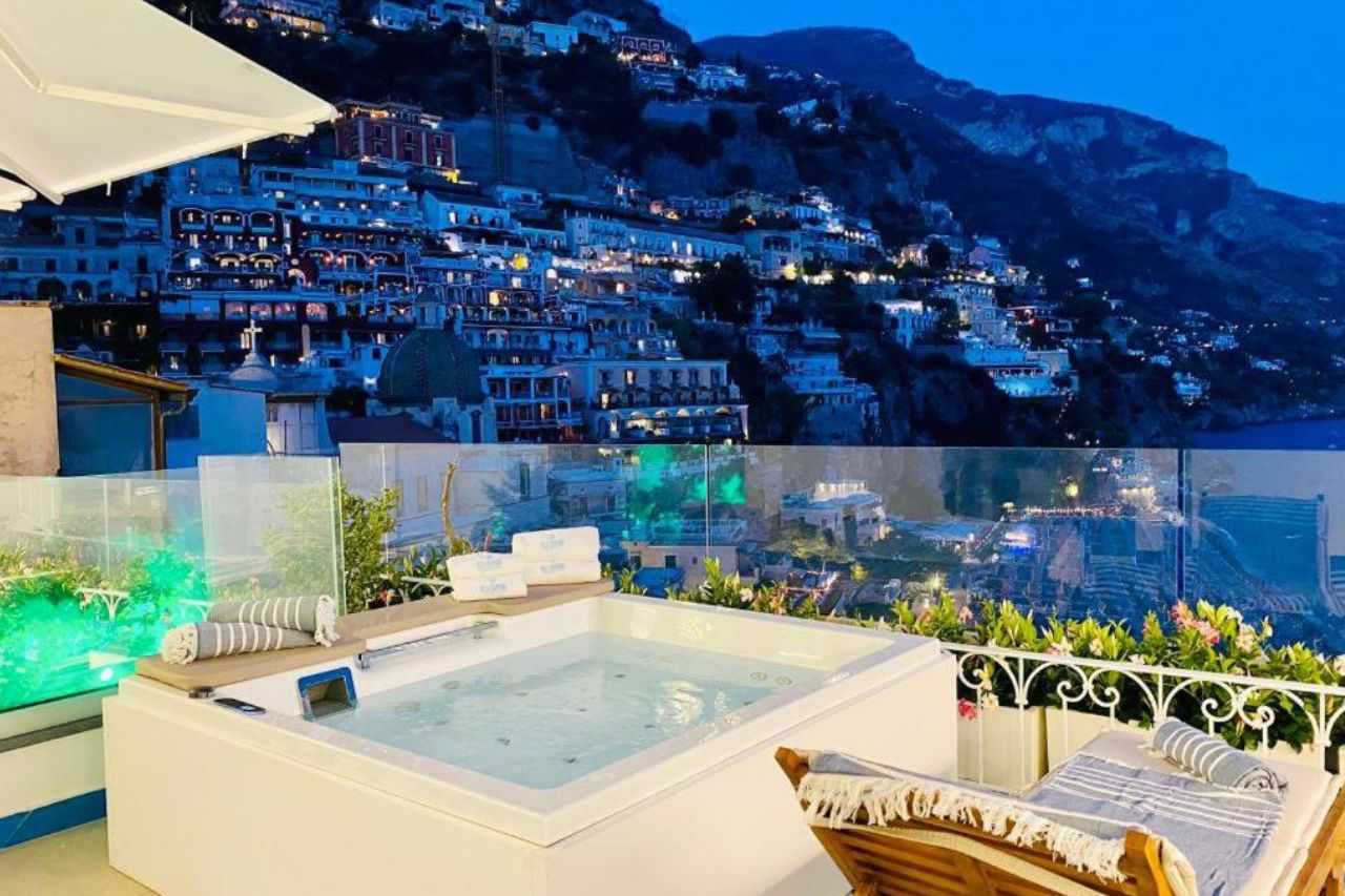 Nighttime view of Positano city from terrace of the Villa Diamond Luxury Suite with luxury tub