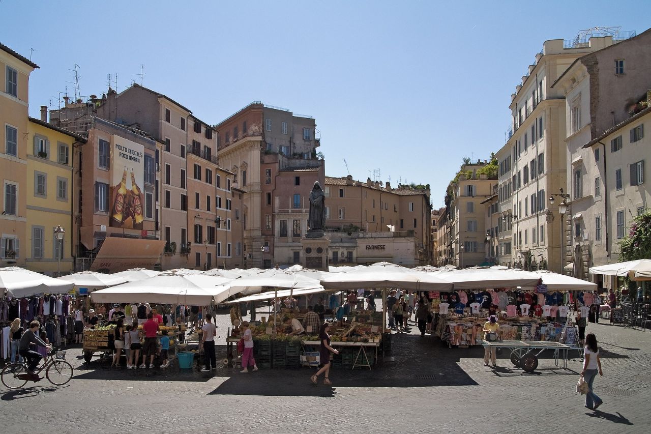 The tourists are visiting the Campo de’ Fiori market in Rome for free