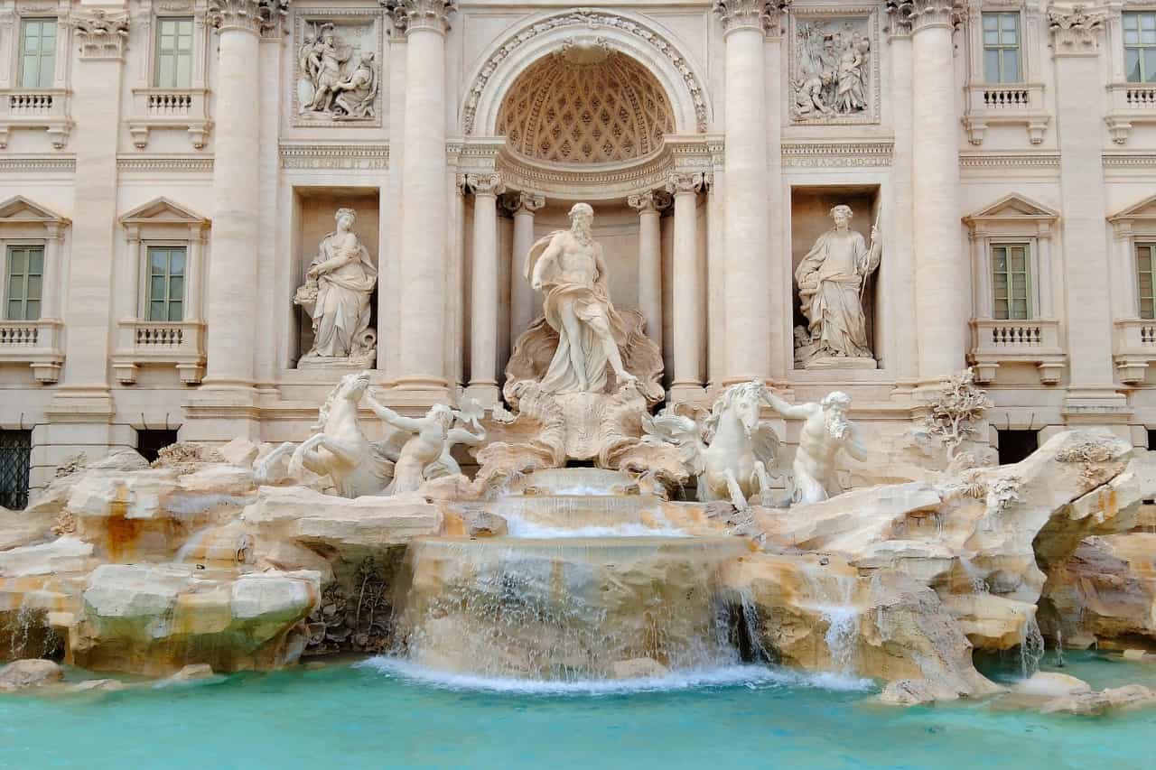 Tourists throw a coin around the Trevi Fountain, one of the most famous monuments in Rome