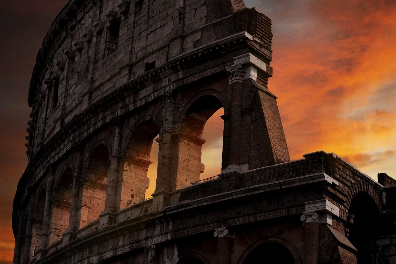 A stunning romantic view of the Roman Colosseum at sunset.