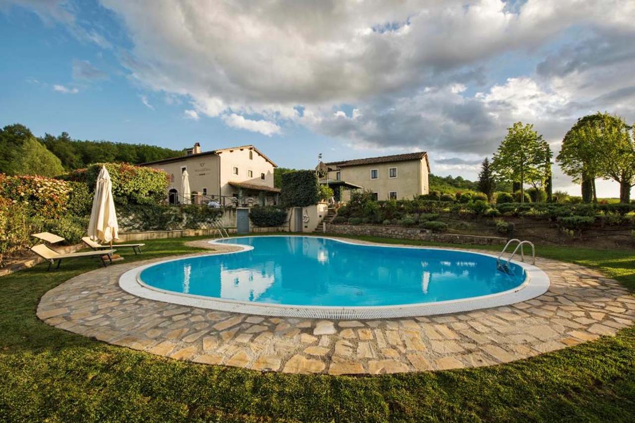 Outdoor pool with greens in Relais Osteria Dell'Orcia