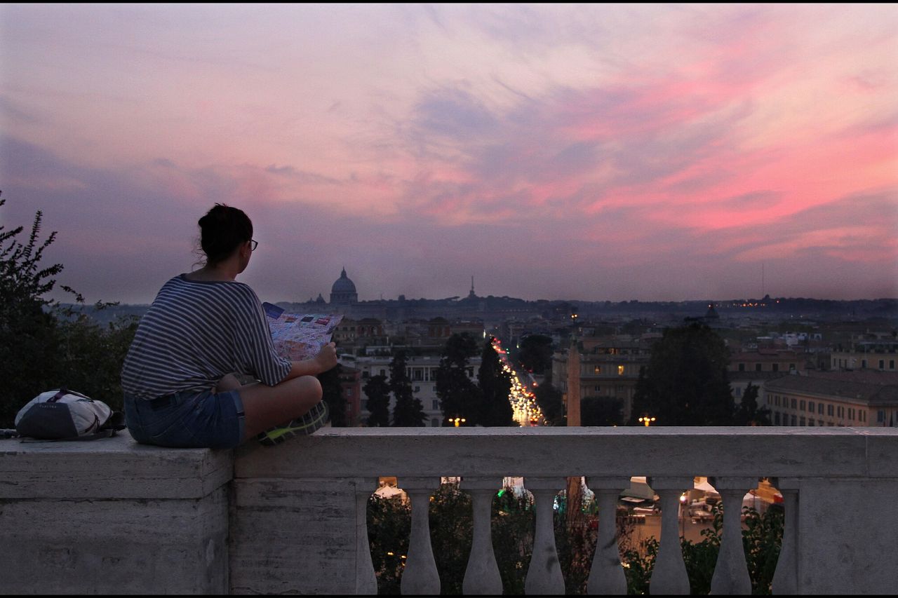 A tourist sat on the Pincio Terrace with A beautiful view of Rome's cityscape