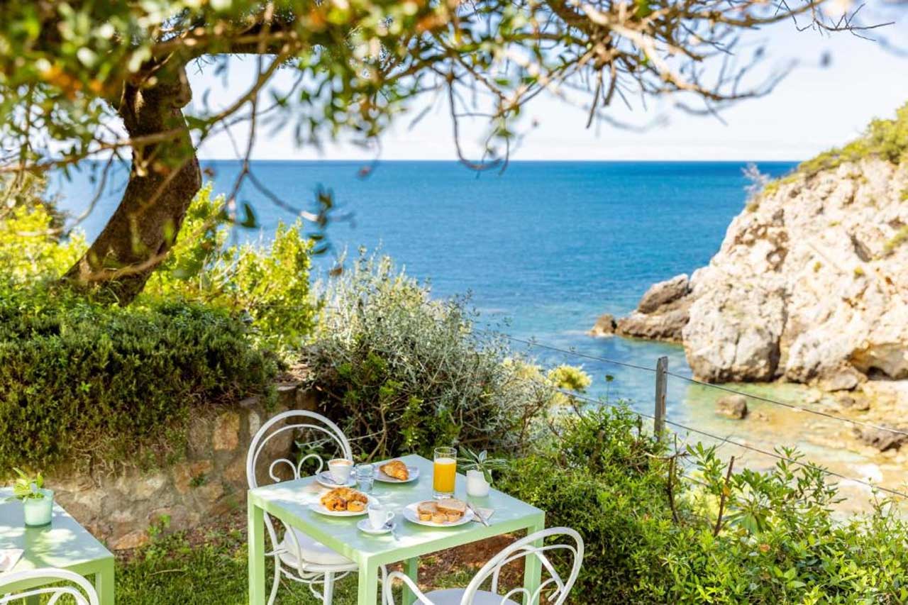 Outdoor dining area with an overlooking view of the sea in Hotel Capo D'Uomo