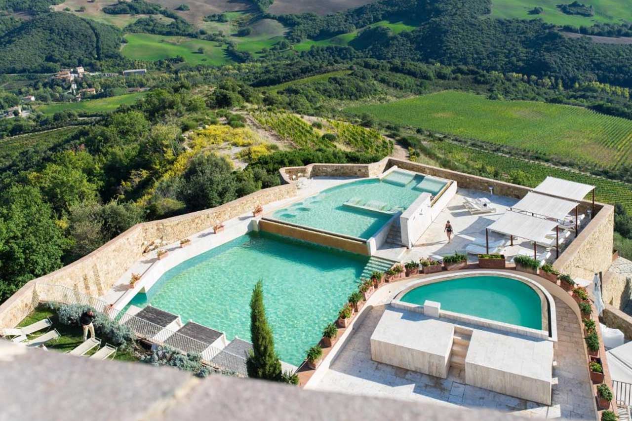 Aerial view of outdoor pools with a breathtaking view of the landscape in Castello di Velona Resort
