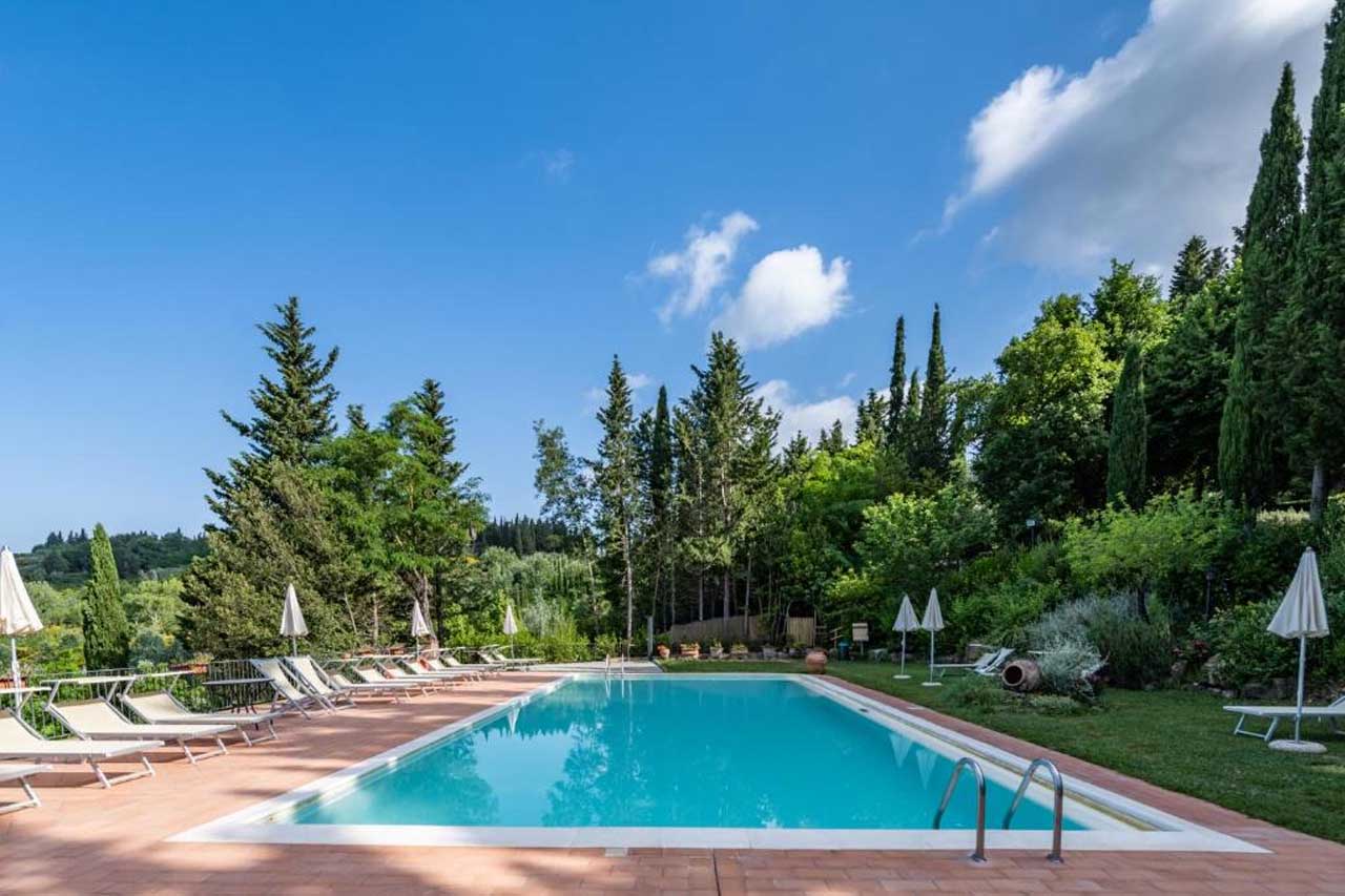 Large outdoor pool in the middle of trees in Podere Mezzastrada