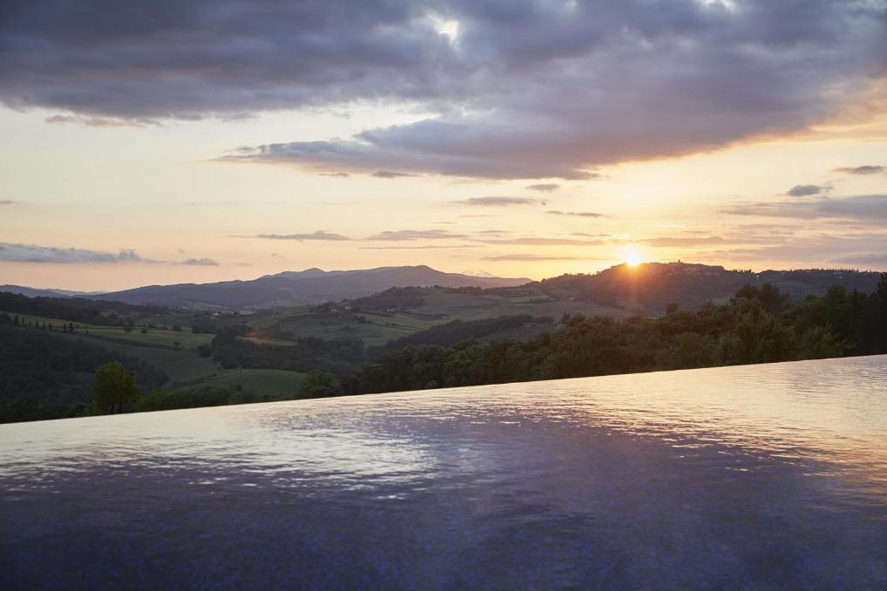 Stunning view of a mountain during sunset from the outdoor pool in Castello di Casole, A Belmond Hotel, Tuscany