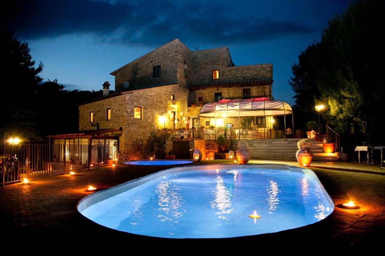 Outdoor pool during nighttime in Il Castelluccio Country Resort