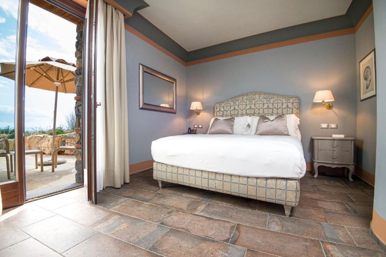 Elegant room with breathtaking view of landscapes from the terrace in The Castello Bonaria Wine & Spa Resort 
