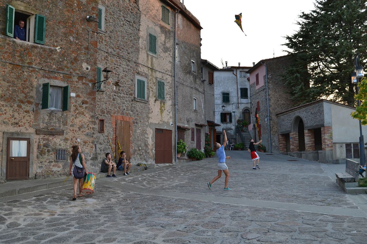 Teenagers playing on the historical and medieval Centro Storico street in Castel Del Piano